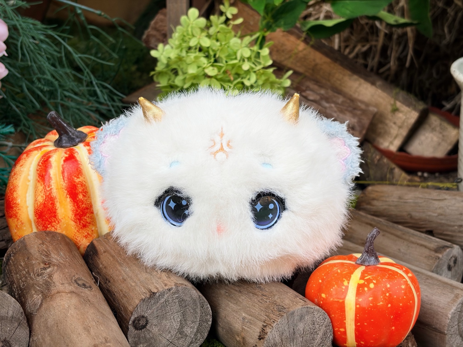 秋日落叶与花朵之间的白泽幼灵毛绒产品实拍